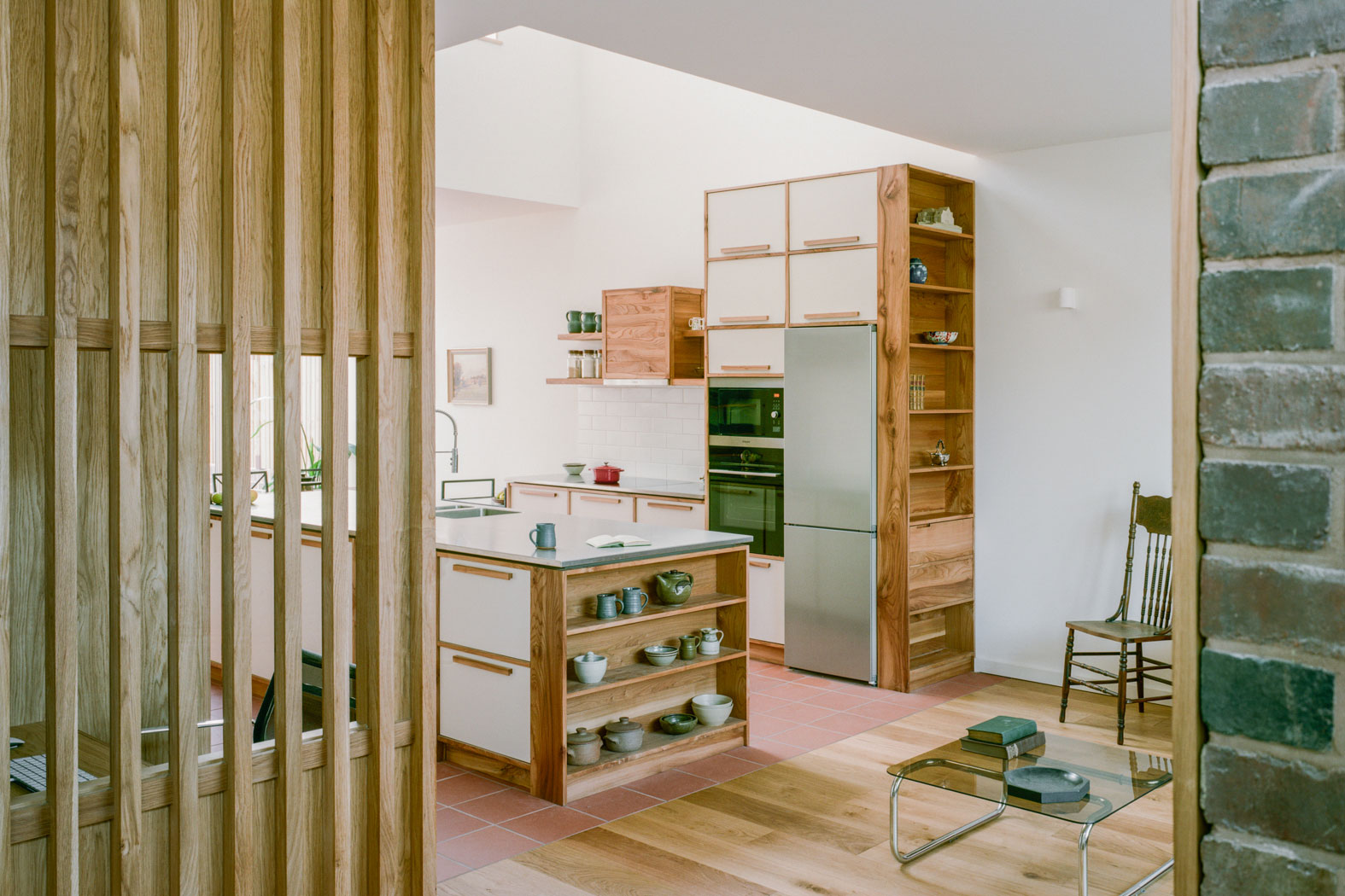 Kitchen in barnet. View shows vintage table and chairs in dining area and kitchen cabinets made from reclaimed timber.