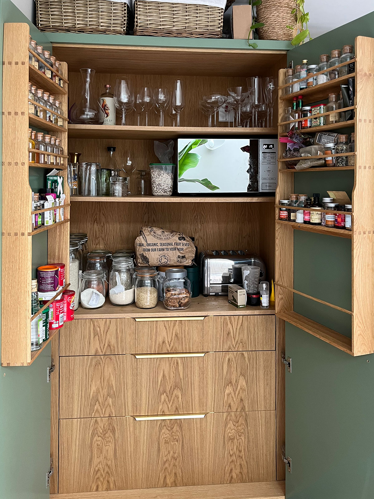 Extending the attention to detail in this oak fluted kitchen, the cabinet interiors were also constructed from oak to tie the whole scheme together. Handmade solid oak spice racks complete the larder.