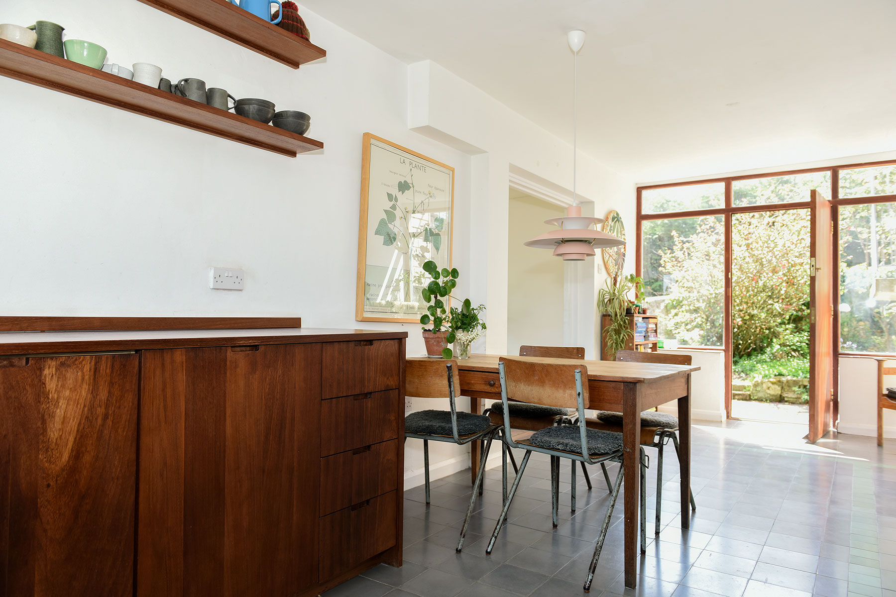 Kitchen in Lewes. View shows vintage table and chairs in dining area and kitchen cabinets made from reclaimed timber.